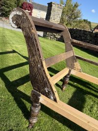 Detailed carvings on antique chaise longue back