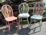 Painted wooden wheel-back chairs. Painted wooden wheel-back chairs with scatter cushions.