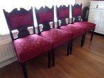 Four carved dining chairs. Set of 4 substantial dining chairs with carved details and back padded coverings, covered in a deep red brocade fabric and detailed braid.