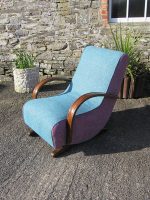 Teal Curved Rocking Chair A teal-coloured curved rocking chair with pink sides, view from the other side.