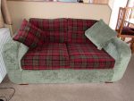 Matching sofa bed in a static caravan. Sofa bed in a static caravan - deep red tartan and contrasting pine green.