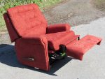 Reclining armchair. Customers' favourite reclining armchair covered in a vibrant orangey-red colour.