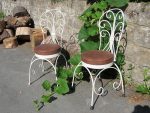 Contemporary metal chairs. Contemporary metal tree-designed chairs with round seat covered in distressed faux leather.