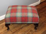 Red/green tartan footstool. A red/green tartan footstool made to match a Parker Knoll Wingback chair.