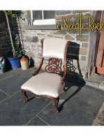 A delicate Victorian ornate chair reupholstered in an off-white satin fabric. A delicate Victorian ornate chair reupholstered in an off-white satin fabric.