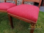 Close-up of dining chairs covered in a red and rosy fabric. Close-up of dining chairs covered in a red and rosy fabric.